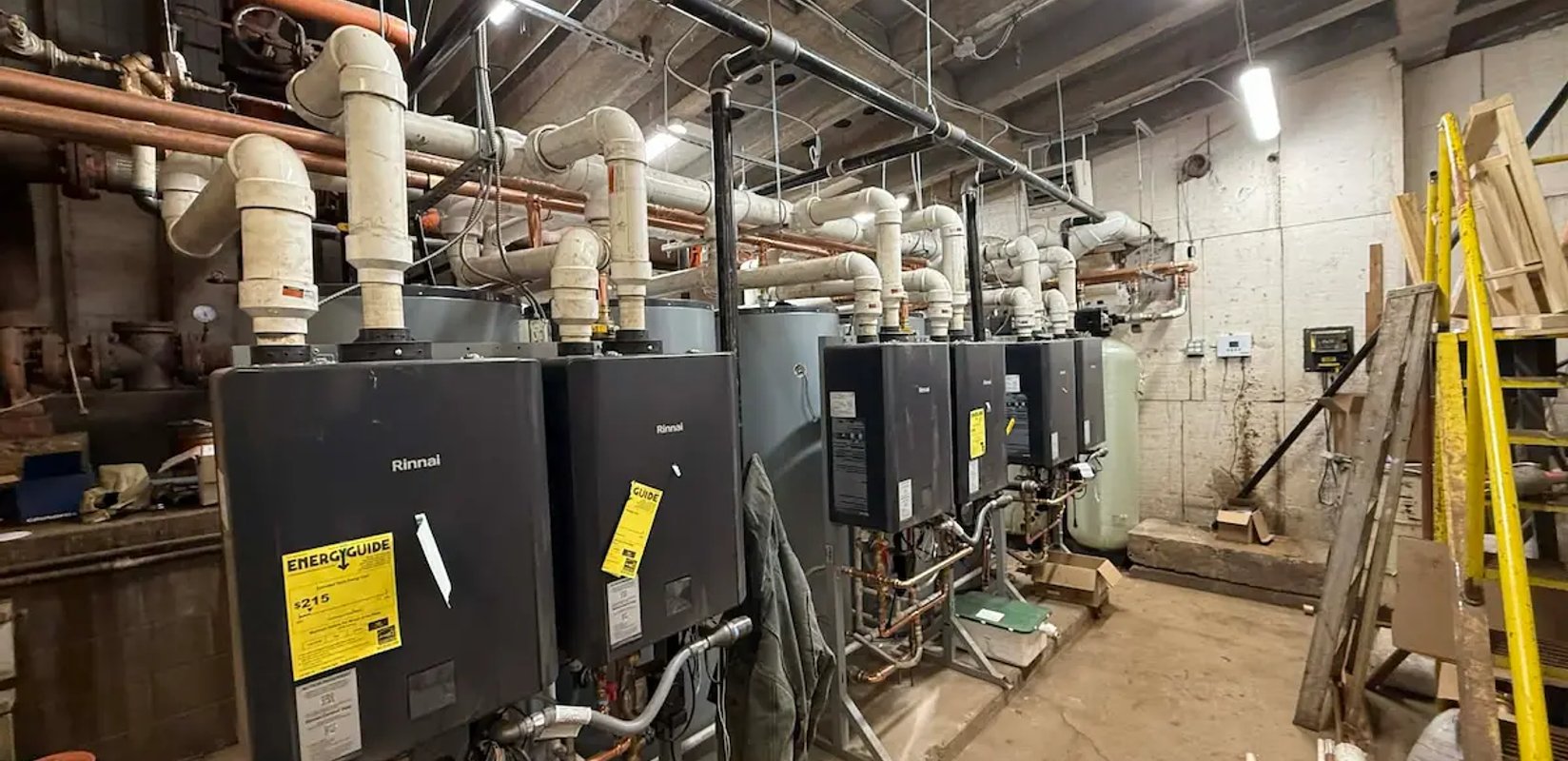 Rinnai tankless water heaters installed in a mechanical room by Squad V Plumbing