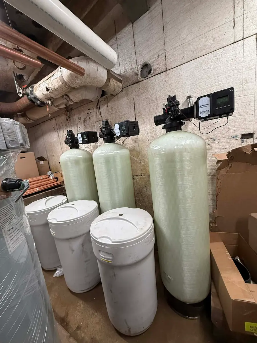 Water treatment tanks and storage barrels in utility room