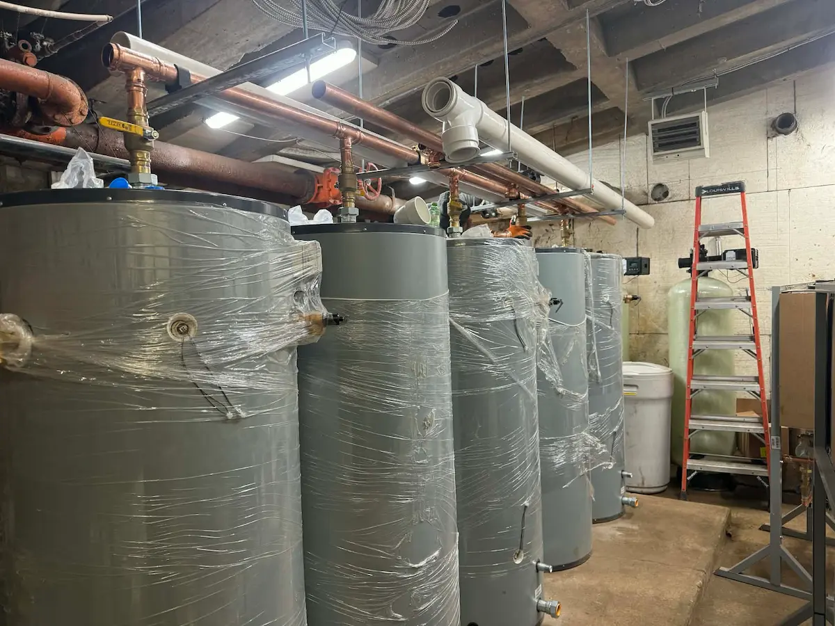 Row of large insulated tanks with overhead copper piping