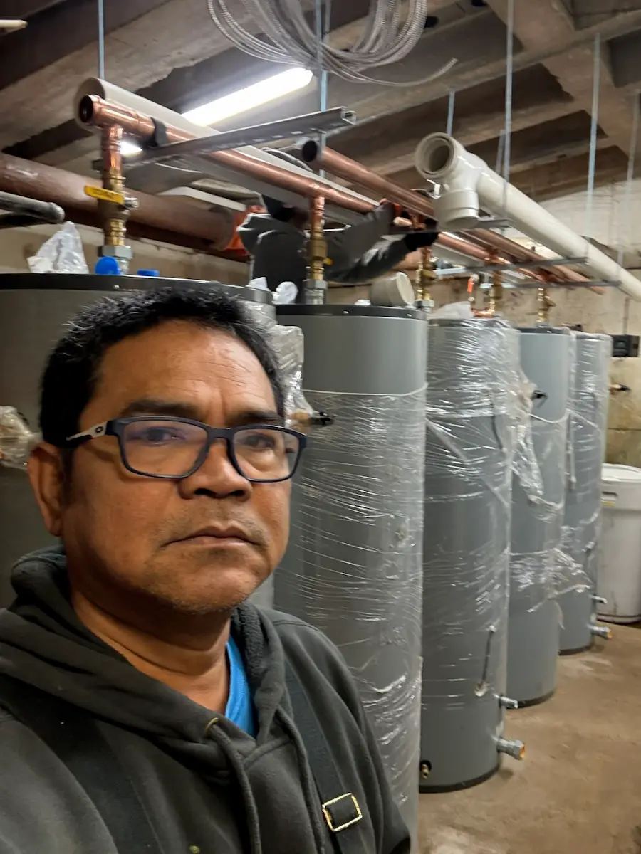 Jobsite selfie in front of large insulated tanks in mechanical room