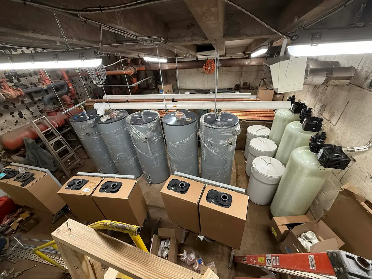 Wide view of mechanical room with insulated tanks and materials