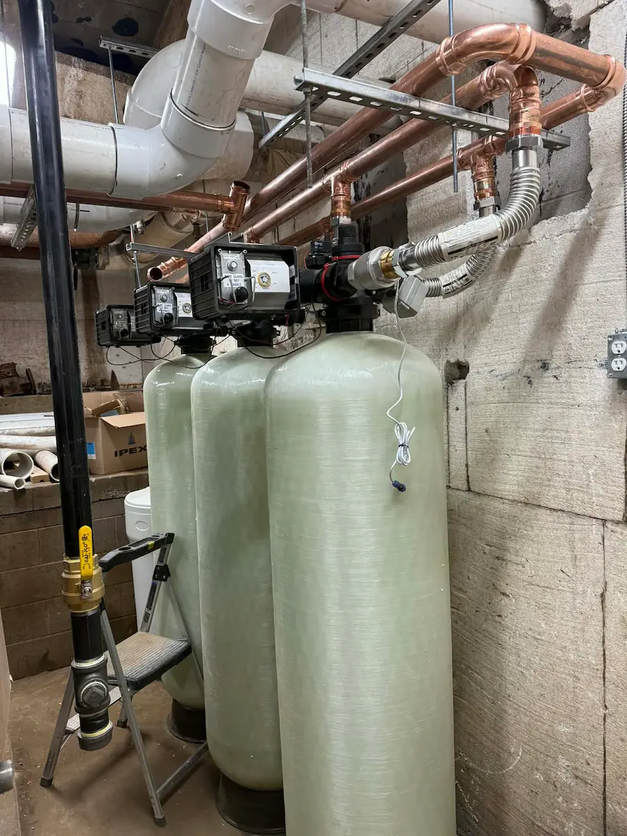 Water treatment tanks and plumbing manifold in utility room
