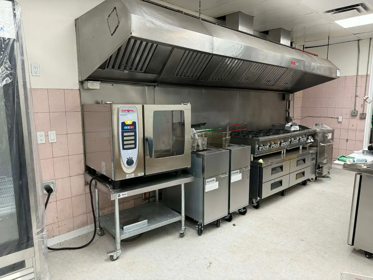Commercial kitchen plumbing and equipment area with sinks and appliances