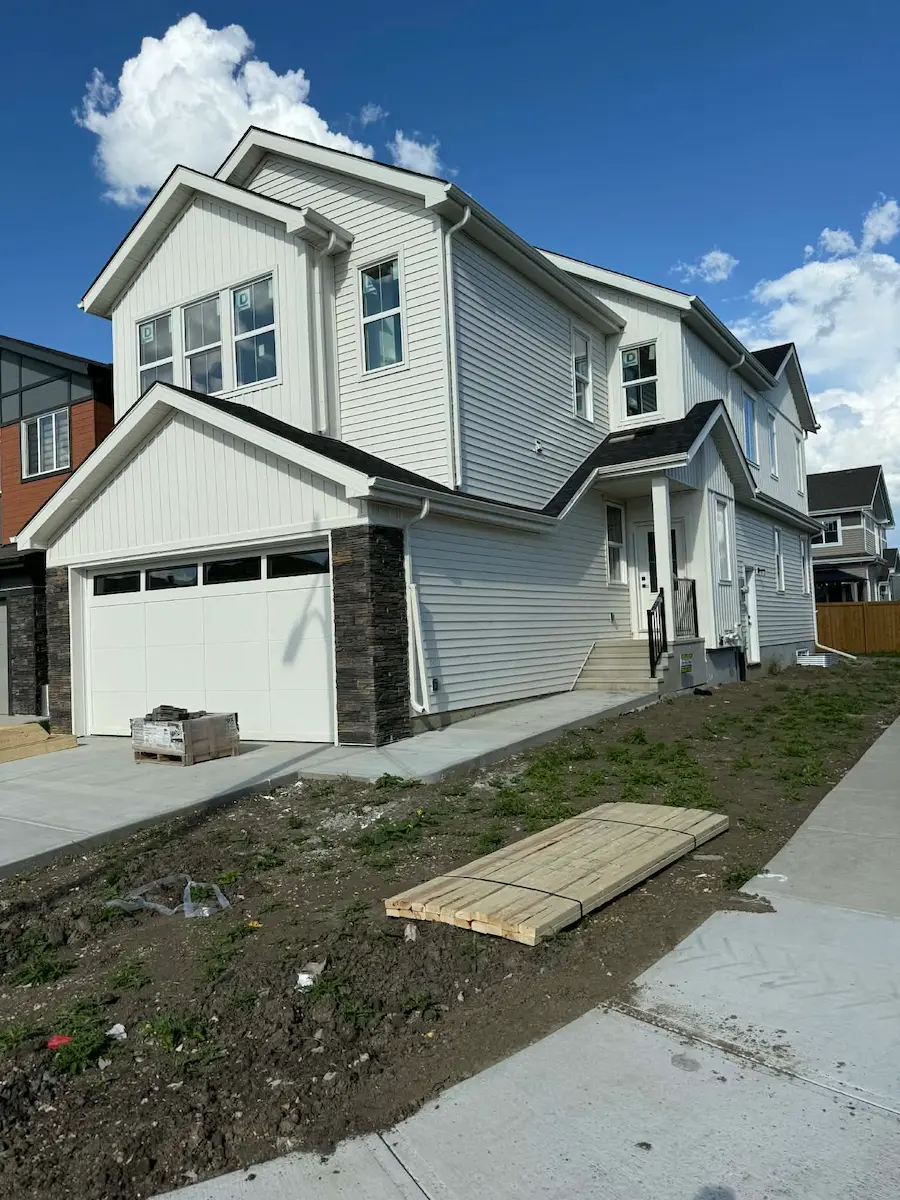 Newly built home exterior with driveway and sidewalk