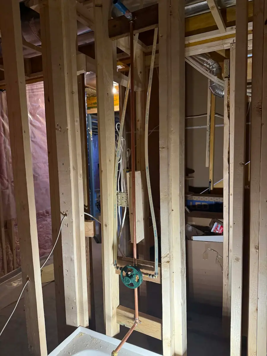 Bathroom framing with rough-in plumbing in progress