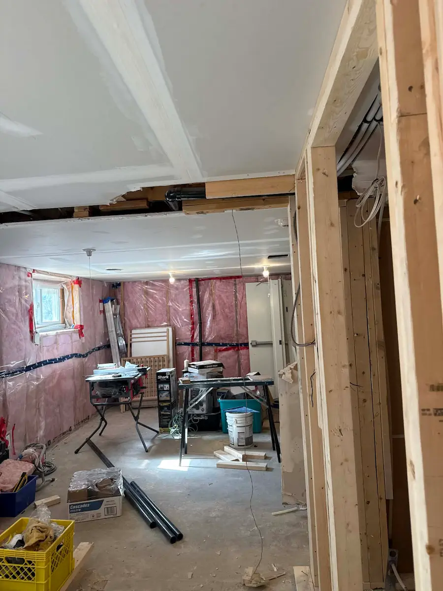 Basement renovation in progress with framing and materials