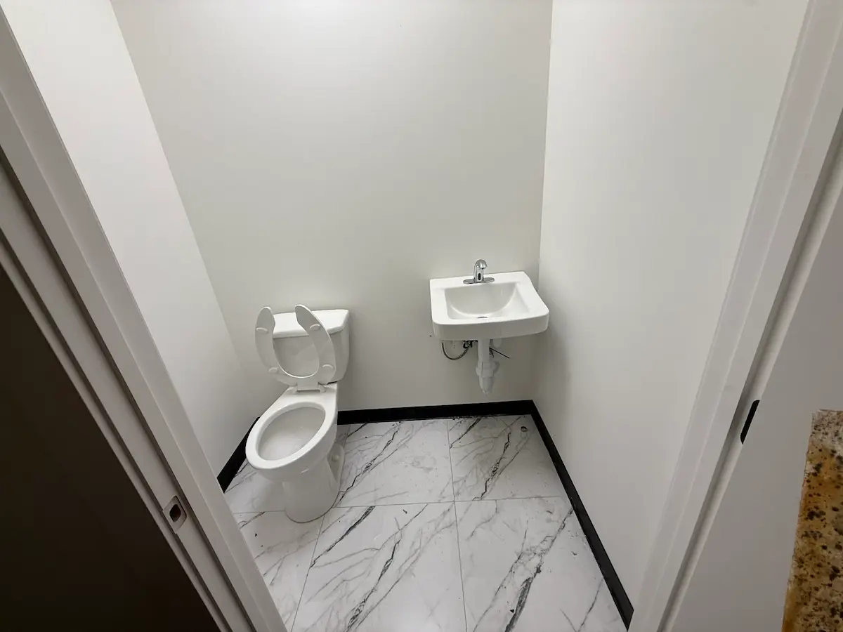 Small bathroom with toilet and wall-mounted sink